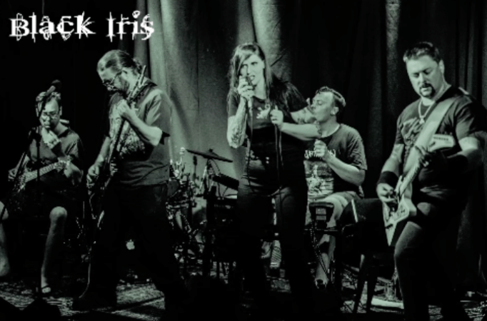 Black and white photo of the band Black Iris on stage, mid song.